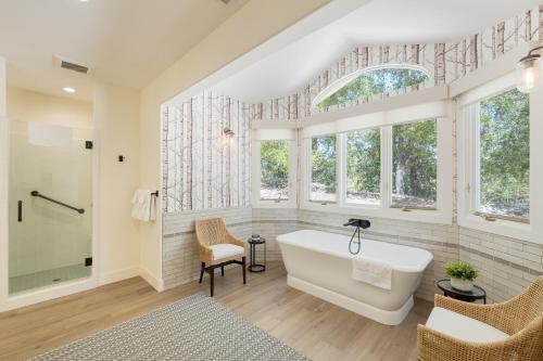 佩索罗伯斯Rancho Robles by AvantStay Vineyard Villa w Views Pool Privacy的一间带白色浴缸和窗户的浴室