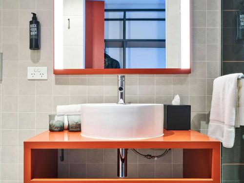 墨尔本ibis Styles Melbourne Airport的一间带水槽和镜子的浴室