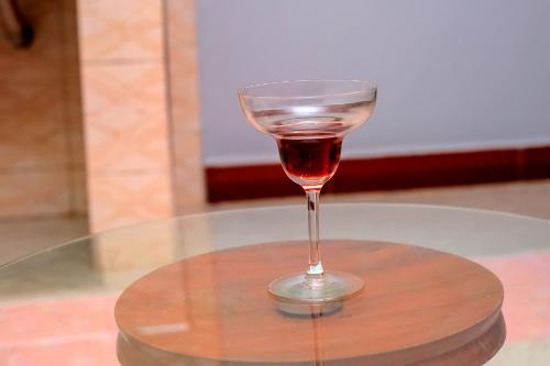BulengaEQUATOR GATES HOTEL Bulega的坐在桌子上的一个葡萄酒杯