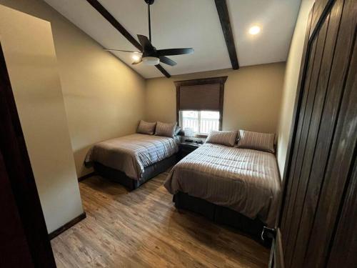 维勒蒙特Whispering Pines Cabin的一间卧室配有两张床和吊扇