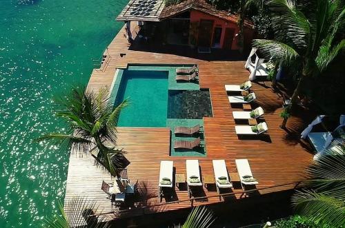安格拉杜斯雷斯美古洛迦曼塔旅馆的一个带椅子的木制甲板和一个水中的游泳池