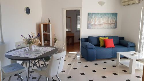 奈维斯Apartments by the sea Njivice, Krk - 5296的客厅配有蓝色的沙发和桌子