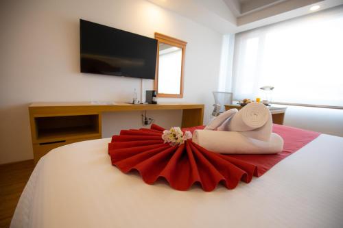 莫雷利亚Hotel Horizon & Convention Center的穿着红色连衣裙躺在床上的妇女