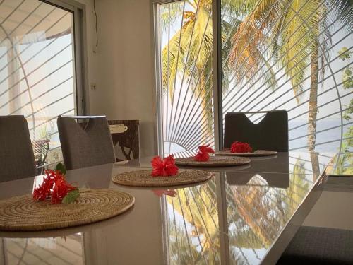 克里比Villa Ebouye的一张桌子,上面有三个盘子,上面有红花