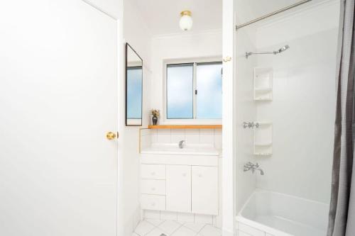 谭伯连山SERENE MOUNTAINVIEW RETREAT / TAMBORINE MOUNTAIN的白色的浴室设有浴缸和淋浴。
