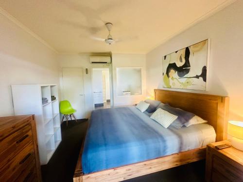 棕榈湾Appartment in Palm Cove的一间卧室配有一张蓝色的床和绿色椅子