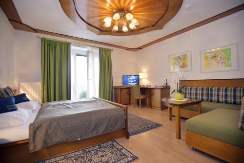 格蒙登施万湖滨酒店的一间卧室配有一张床、一张沙发和一个窗口
