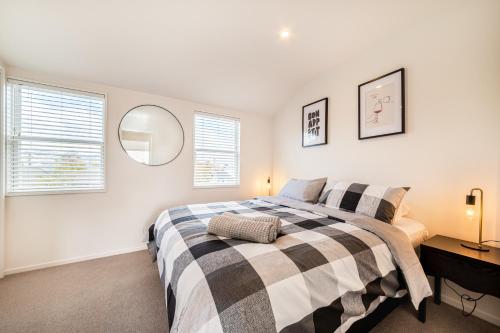 基督城Retro Retreat in Christchurch的一间卧室设有一张床和两个窗户。