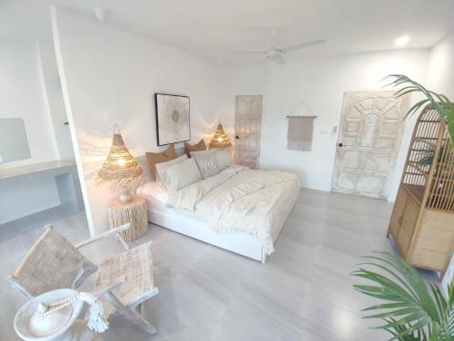 苏梅岛3BR Villa, Bangrak Beach, Koh Samui的一间白色的卧室,配有床、桌子和植物