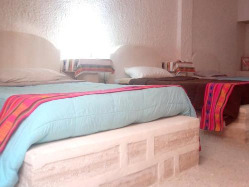 乌尤尼Hostal Beds of salt Ga的一间设有两张床的房间,内设一张长凳