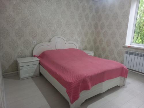 KerbenZholaman的卧室配有一张带红色毯子的白色床