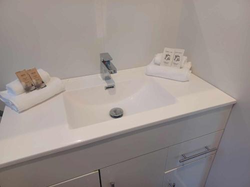 纳皮尔Aqua Apartment的白色浴室水槽和2条毛巾
