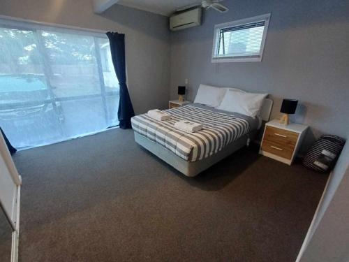 纳皮尔Aqua Apartment的一间卧室设有一张床和一个大窗户