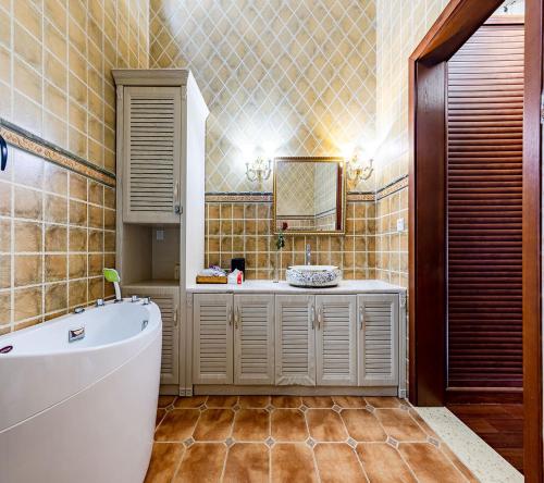 昆明Annie Dianchi Lake Villas的带浴缸、水槽和镜子的浴室