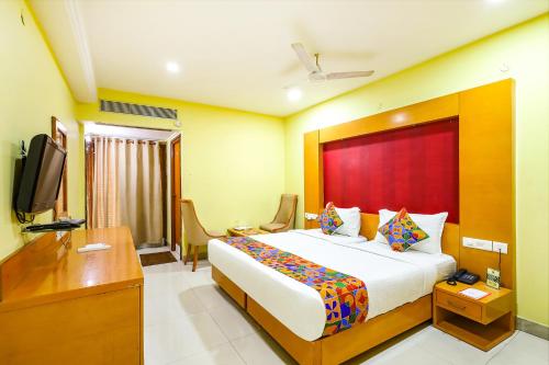 钦奈FabHotel Prime Mahalaya Residency的酒店客房设有一张大床和一台电视。