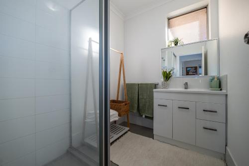 珀斯2B cozy house near the airport的白色的浴室设有水槽和镜子