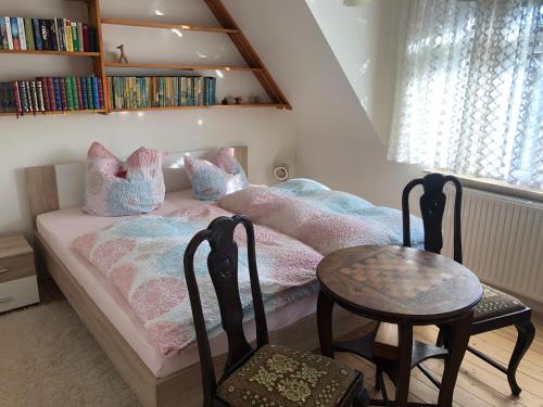 Talblick的一间卧室配有一张带两把椅子和一张桌子的床。