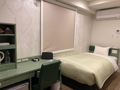 福冈Hotel Front Inn Fukuoka Airport的一间卧室配有一张床和一张带电脑的书桌