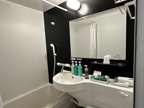 福岛Hotel Route Inn Fukushima Nishi Inter的浴室设有白色水槽和镜子