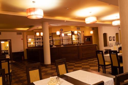 Kerepes维斯维塔利斯酒店的一间带桌椅的餐厅和一间酒吧