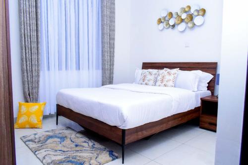 马查科斯Amalia Apartments Syokimau的一间卧室配有带白色床单和枕头的床。