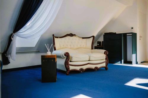 PoniatowaStacja Kultura的卧室配有白色的床和蓝色地毯