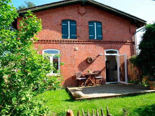 BünsdorfZeitweise的一座红色砖屋,在院子里设有木甲板
