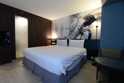 雅加达HORU HOTEL MANGGA DUA SQUARE的卧室配有一张白色大床,墙上挂有自行车画