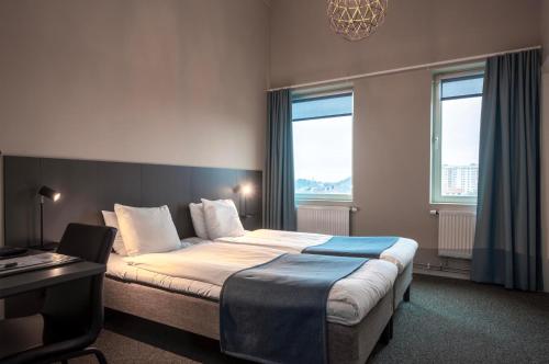 哥德堡Kviberg Park Hotel & Conference的酒店客房设有一张床、一张书桌和窗户。