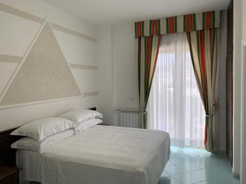 伊斯基亚康特酒店的卧室配有白色的床和窗户。