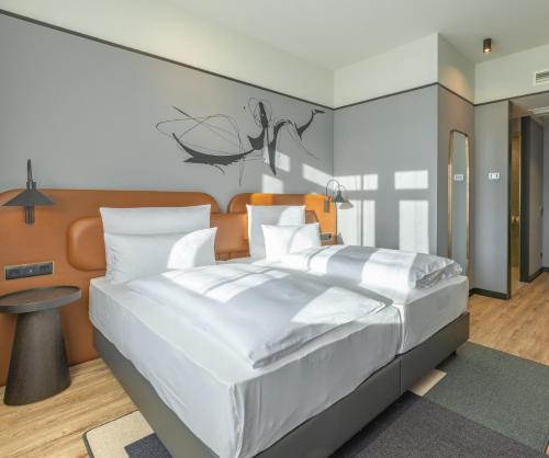 柏林TITANIC Comfort Kurfürstendamm的卧室配有一张白色的大床和一张桌子