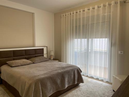 斯库台Adra's apartment的一间卧室设有一张床和一个大窗户