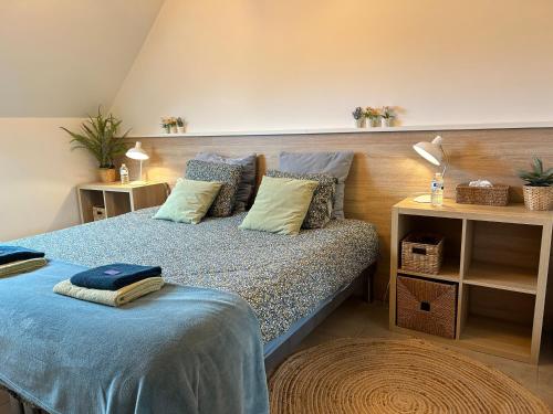 EllezellesAu Coeur des Collines, Noisette的一间卧室配有一张带蓝色床单和枕头的床。