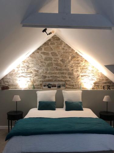 普洛埃默Entre terre et mer的一间卧室设有一张带石墙的大床