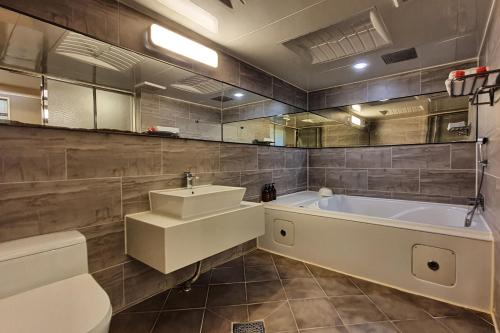 蔚山Palace Hotel的带浴缸、盥洗盆和卫生间的浴室