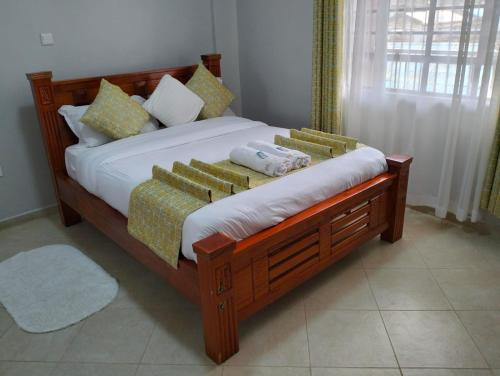 奈瓦沙JNJ luxury homes的一间卧室配有带枕头的木床