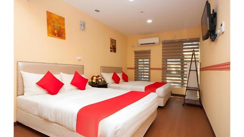 古邦阁亮Bintang Square Hotel的配有红色和白色床单的客房内的两张床