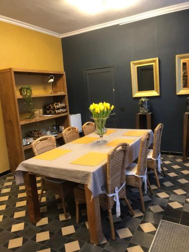 阿尔特Beaux Temps b&b的用餐室配有黄色鲜花的桌子