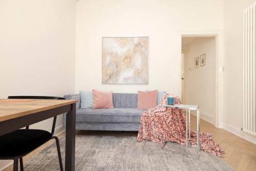 爱丁堡Modern flat in City Centre - For up to 3 guests的客厅配有蓝色的沙发和桌子