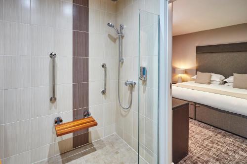 奥本The Ranald Hotel的带淋浴的浴室和客房内的一张床