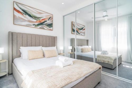 悉尼Tranquil Haven in Balmain的一间卧室配有两张床和镜子