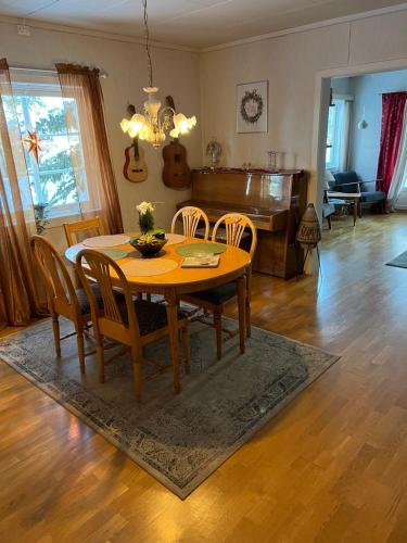 ValmenFamilievennlig bolig i Trysil的一间带桌椅和钢琴的用餐室