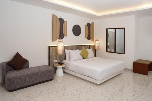 吉利特拉旺安Jambuluwuk Oceano Gili Trawangan的卧室配有白色的床和椅子