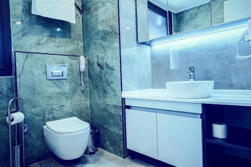 伊斯坦布尔ONKA OTELCİLİK TURİZM TİCARET LİMİTED ŞİRKETi的浴室配有白色卫生间和盥洗盆。