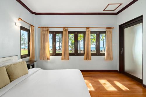 象岛Koh Chang Longstay Resort的卧室配有白色的床和窗户。