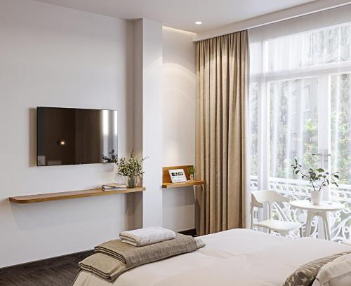 胡志明市LANGHAM Boutiqu Hotel的一间卧室设有一张床和一个大窗户