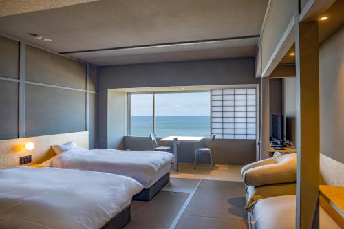 鹤冈市Kameya Hotel的酒店客房设有两张床,享有海景。