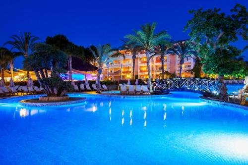 穆罗海滩VIVA Blue & Spa的一个晚上的游泳池,酒店背景