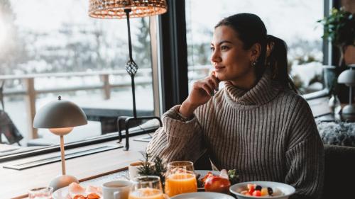 GaustablikkGaustablikk Fjellresort的坐在餐馆桌子旁的一位女士用手机说话