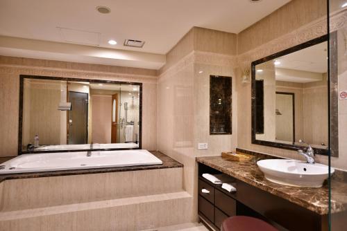 台北台北唯客乐饭店的带浴缸、水槽和镜子的浴室